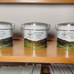 Three Charlie's Concoctions tea tins on a wooden shelf: Deep Sleep, Lemon Lavender, and Candy Cane Concoction
